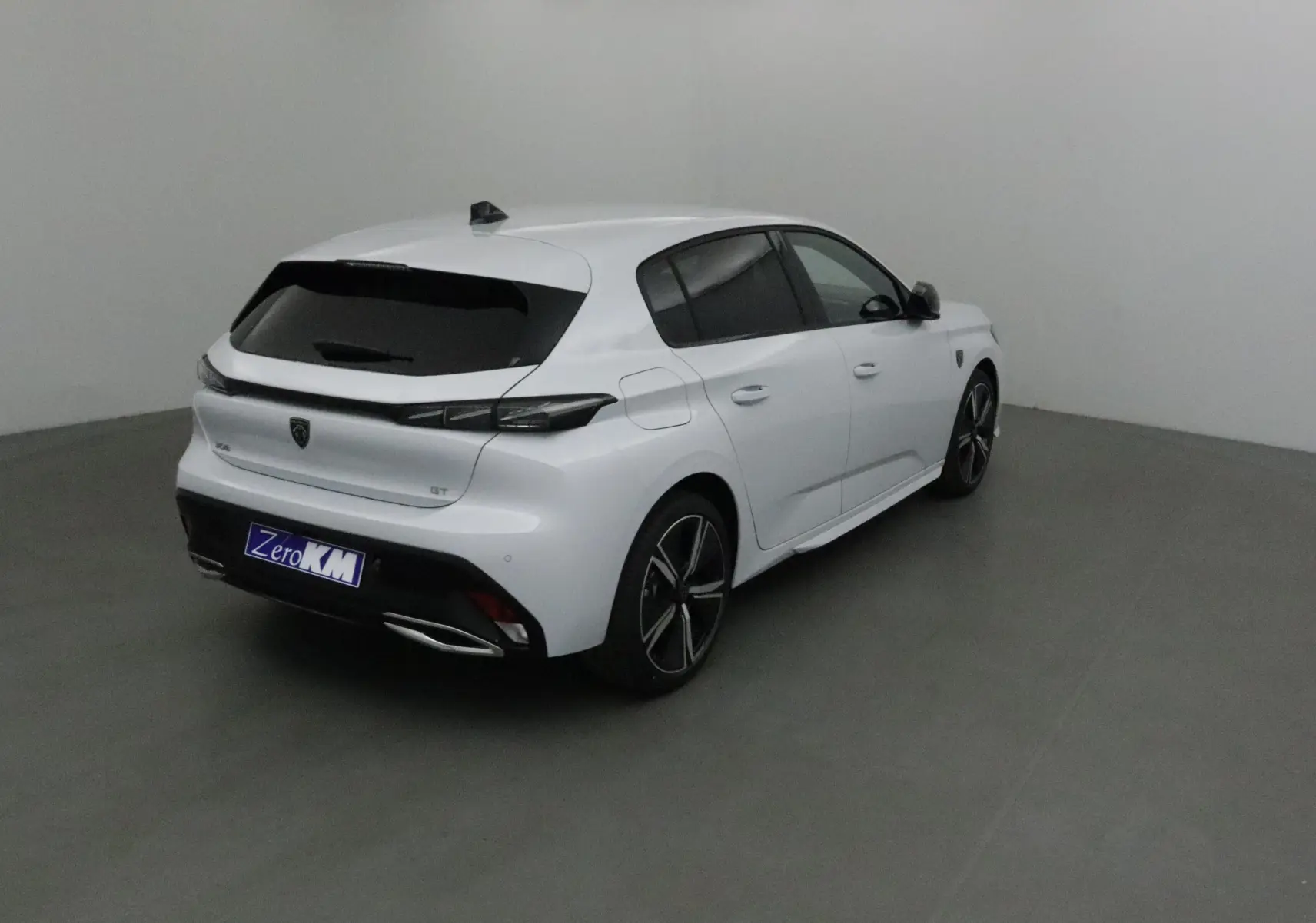 Peugeot 308 GT blanc Okenite vue 3/4 arrière droit, avec jantes alliage et vitres teintées.