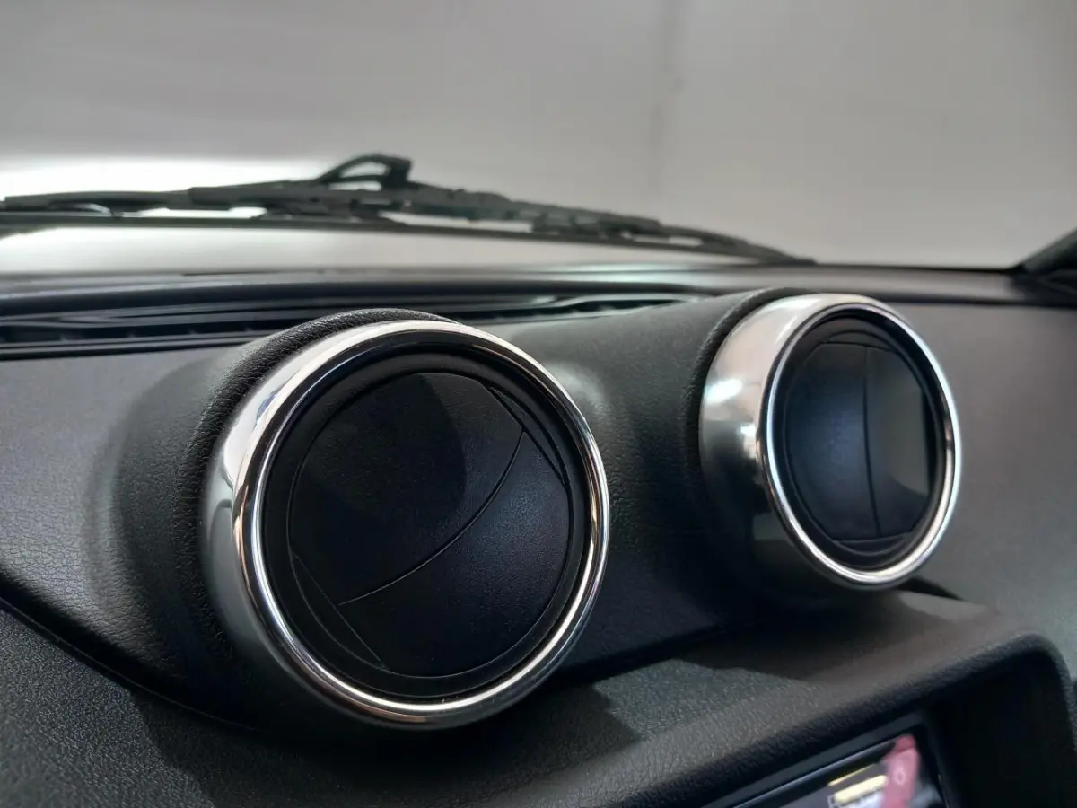 Gros plan sur les aérateurs ronds chromés du tableau de bord de l'AIXAM MEGA bleu électrique 2026.