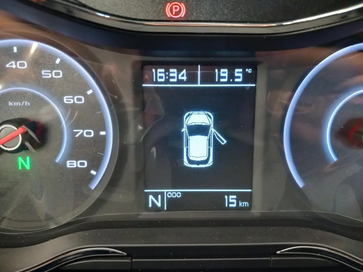 Tableau de bord numérique de l'AIXAM MEGA bleu, affichant la vitesse, température et porte conducteur ouverte.