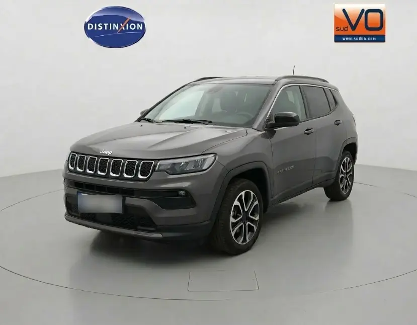Jeep Compass gris 3/4 avant droit, jantes alliage 18 pouces, calandre distinctive et rétroviseurs noirs.