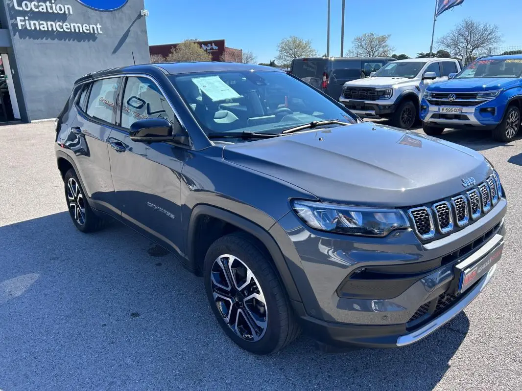 Jeep Compass gris vue 3/4 avant droit, jantes alliage 18 pouces et calandre distinctive à sept fentes.