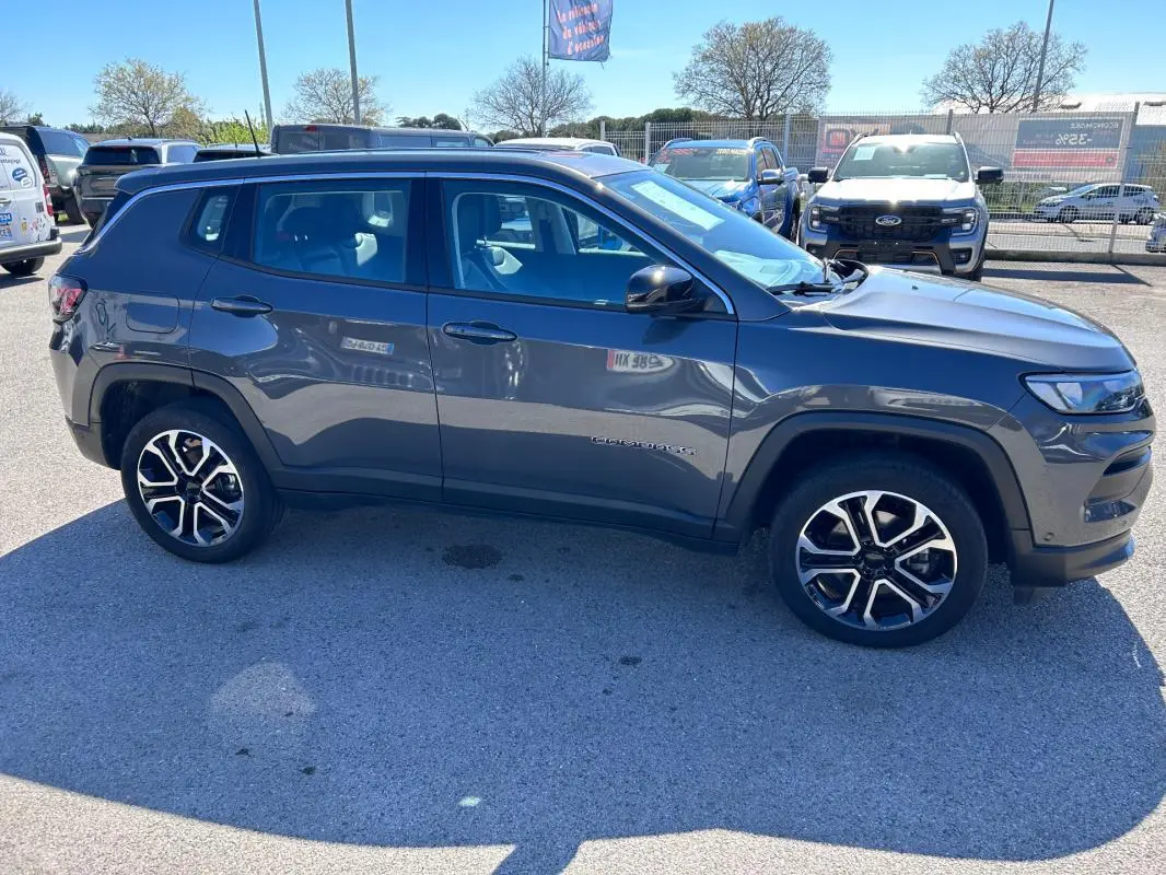 Vue de profil côté gauche d’un Jeep Compass gris 2024 avec jantes alliage 18 pouces sur parking extérieur.