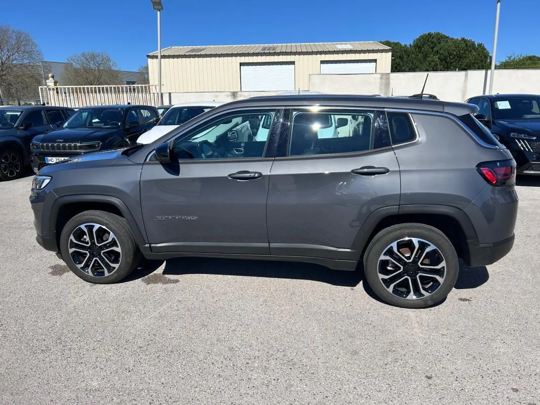 Vue de profil côté gauche d’un Jeep Compass gris 2024 avec jantes alliage 18 pouces et toit contrasté noir.
