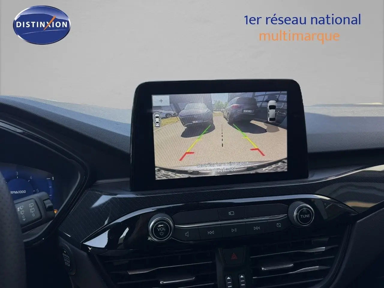 Vue du tableau de bord du Ford Kuga 2024 avec écran central affichant la caméra de recul en marche.