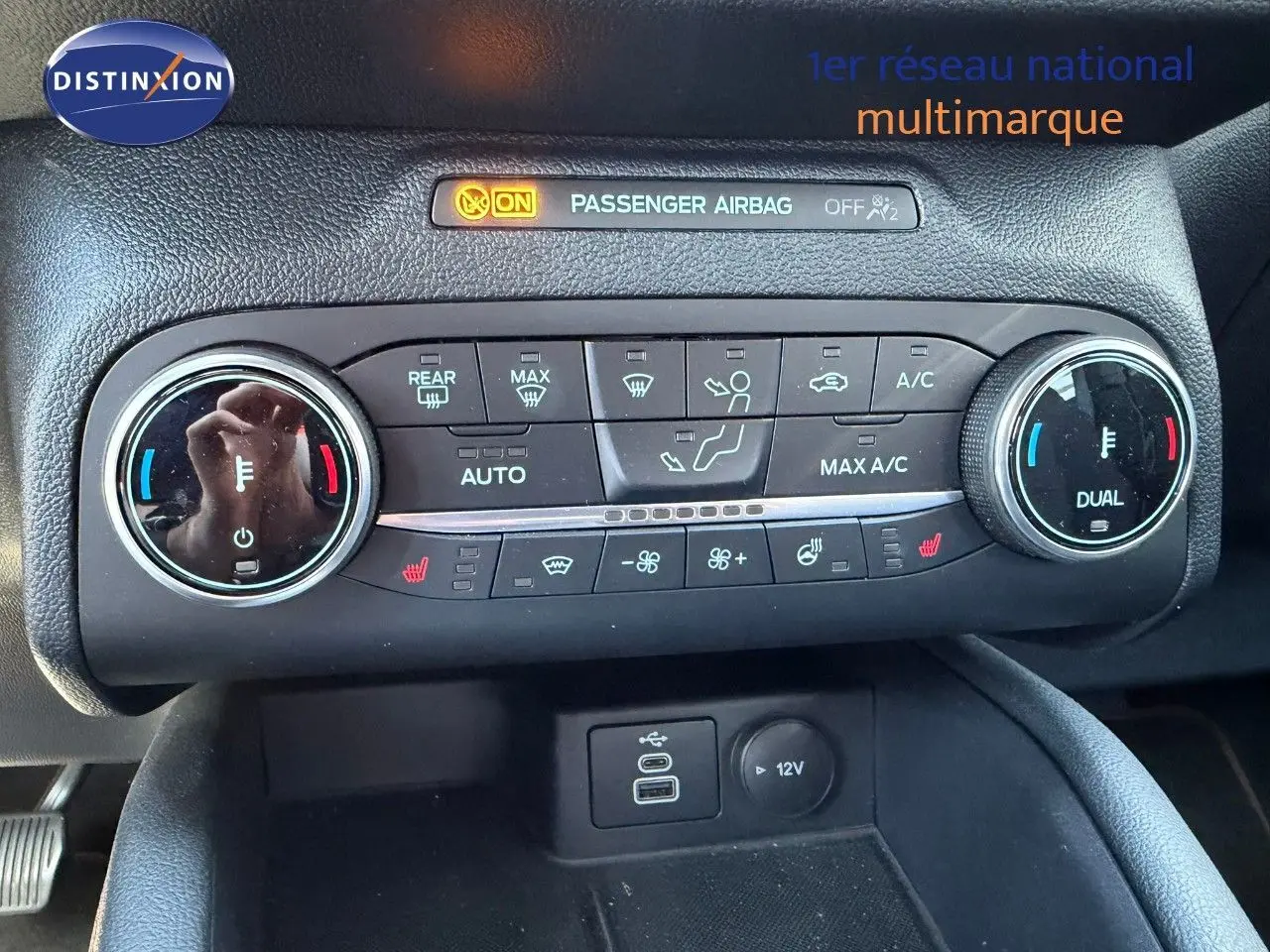 Gros plan sur la console de climatisation du Ford Kuga gris magnétique, avec commandes digitales et ports USB visibles.