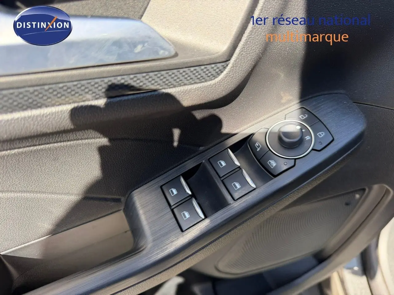 Détail des commandes de lève-vitres et rétroviseurs sur la porte côté gauche du Ford Kuga gris magnétique 2024.
