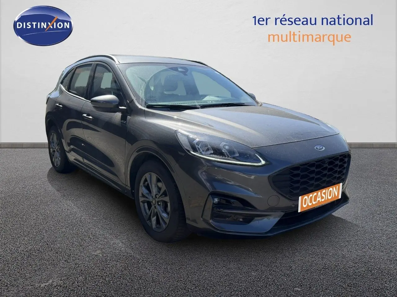 Ford Kuga 2024 gris magnétique métal en 3/4 avant droit avec calandre noire et jantes alliage.