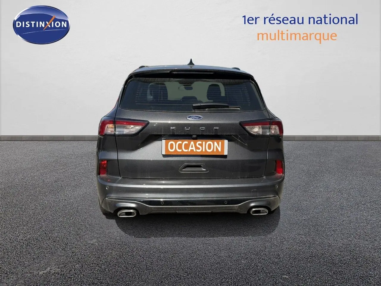 Vue arrière d'un Ford Kuga 2024 gris magnétique métallisé avec double sortie d'échappement et feux LED.