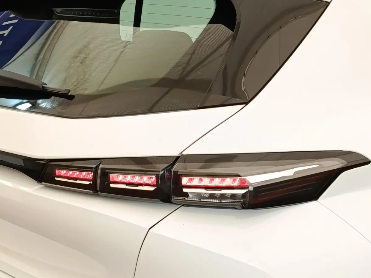 Gros plan sur les feux arrière LED rouges d'une Peugeot 308 blanche, vue côté gauche arrière.