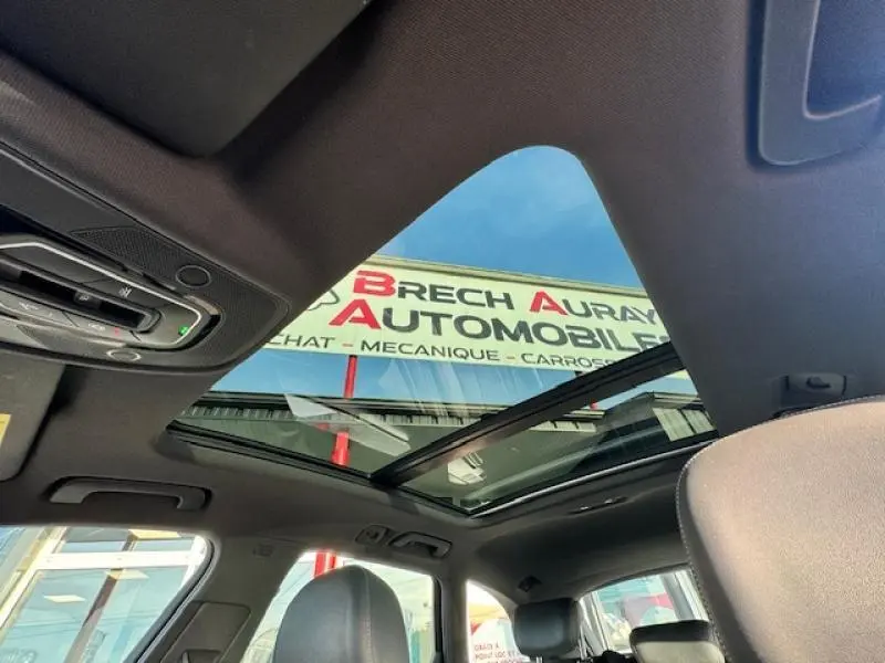Toit panoramique ouvert vu de l'intérieur de l'Audi S4 Avant 2017 avec ciel bleu visible à travers le verre.
