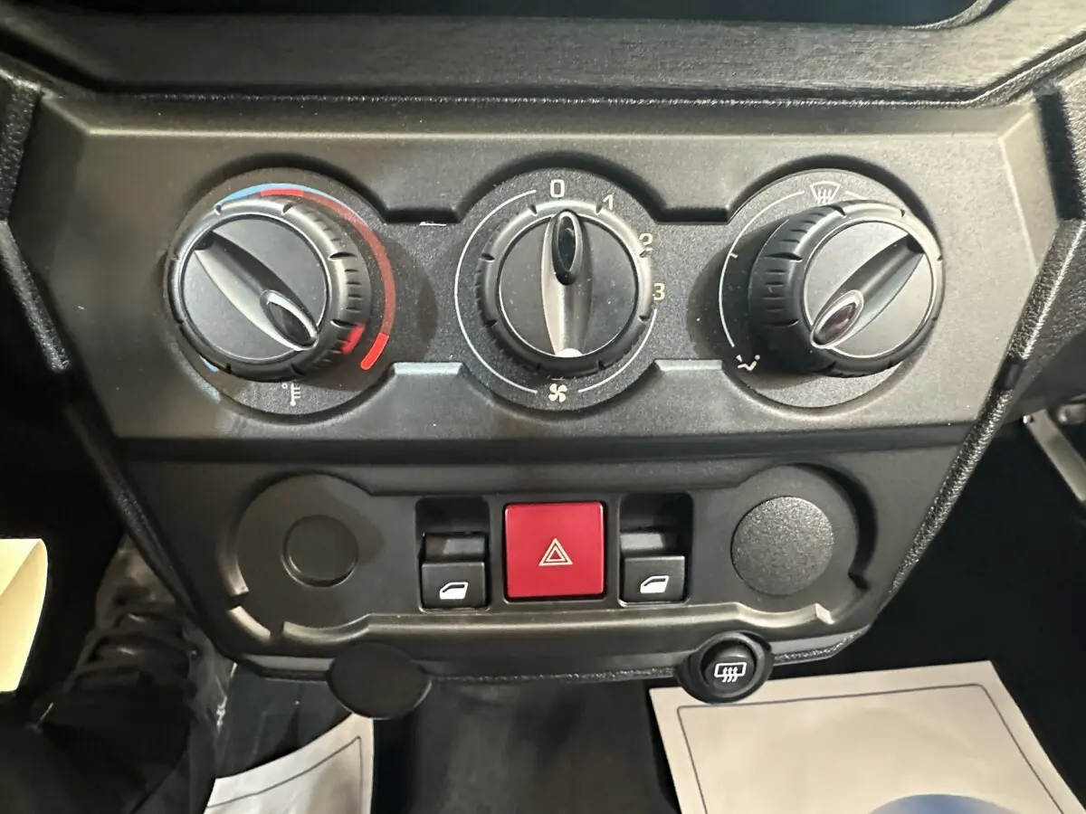 Gros plan sur les commandes de climatisation et les boutons de l’AIXAM AMBITION 0.5 CITY PACK blanc, tableau de bord intérieur.