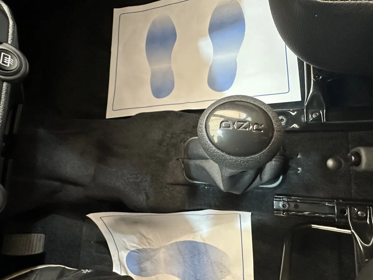 Vue rapprochée du levier de vitesses automatique noir dans l’habitacle d’une Aixam Ambition 0.5 City Pack blanche.