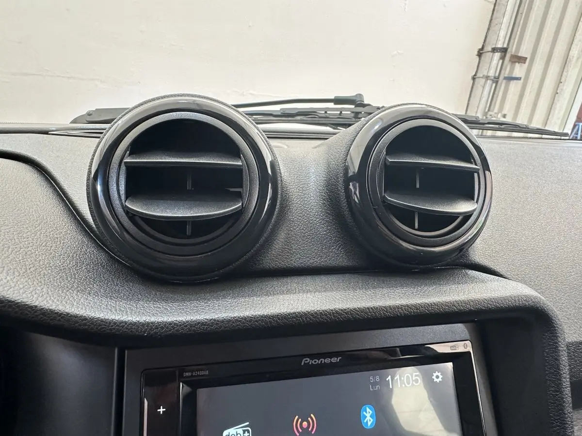 Gros plan sur la console centrale de l'AIXAM AMBITION 0.5 CITY PACK 2026, avec aérateurs ronds noirs et écran tactile Pioneer.