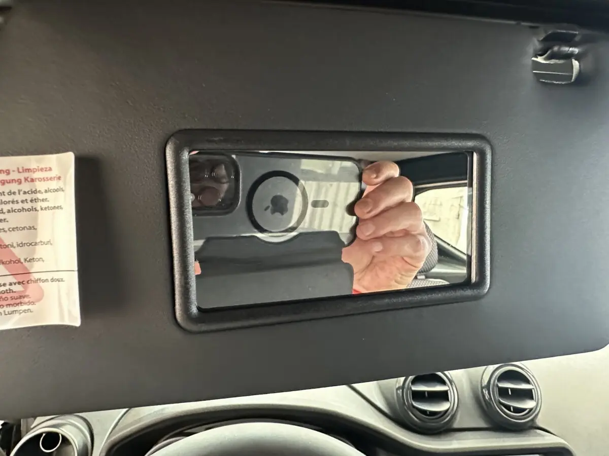 Intérieur de l'AIXAM AMBITION 0.5 CITY PACK 2026, vue sur le miroir de soleil et partie du tableau de bord noir.