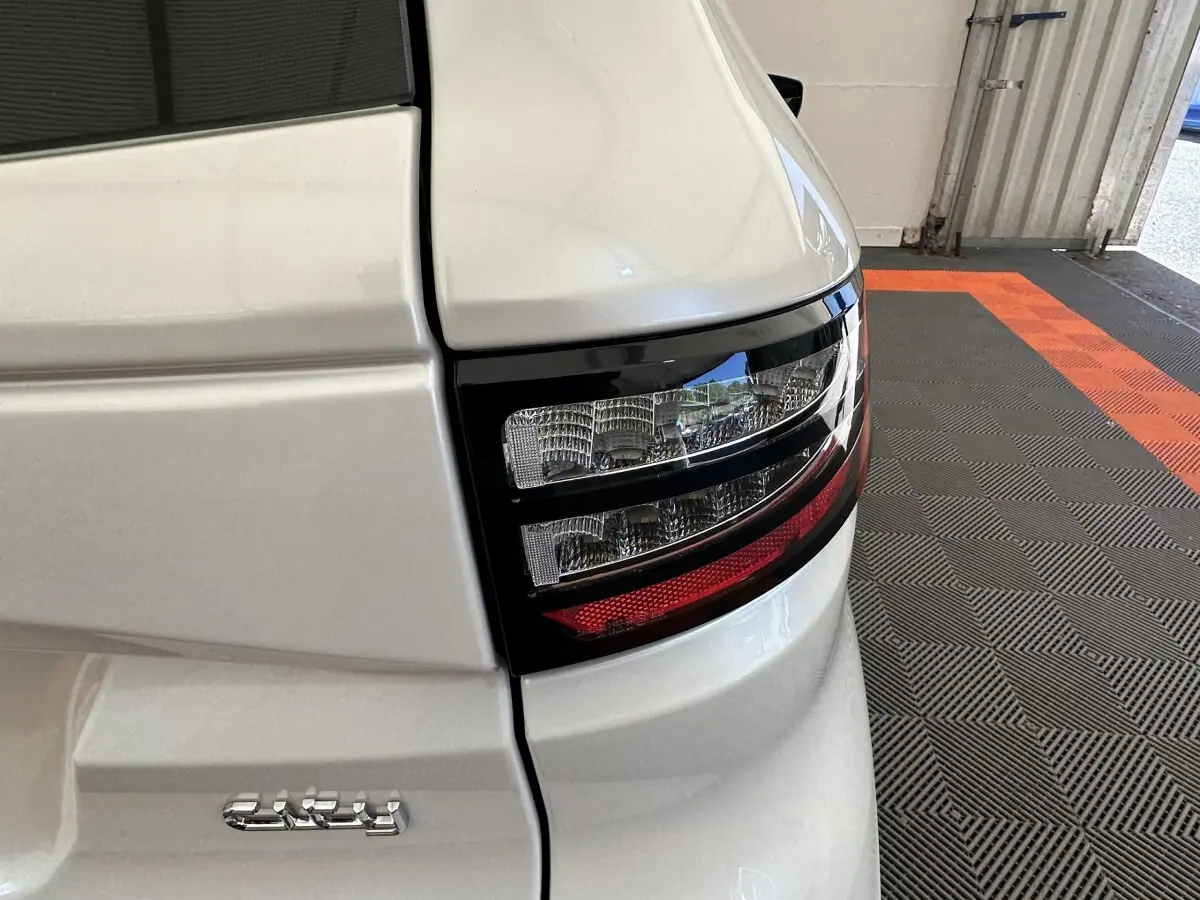 Gros plan sur le feu arrière droit d’une Aixam Ambition blanc 2026 avec détails du hayon et éclairage bicolore.