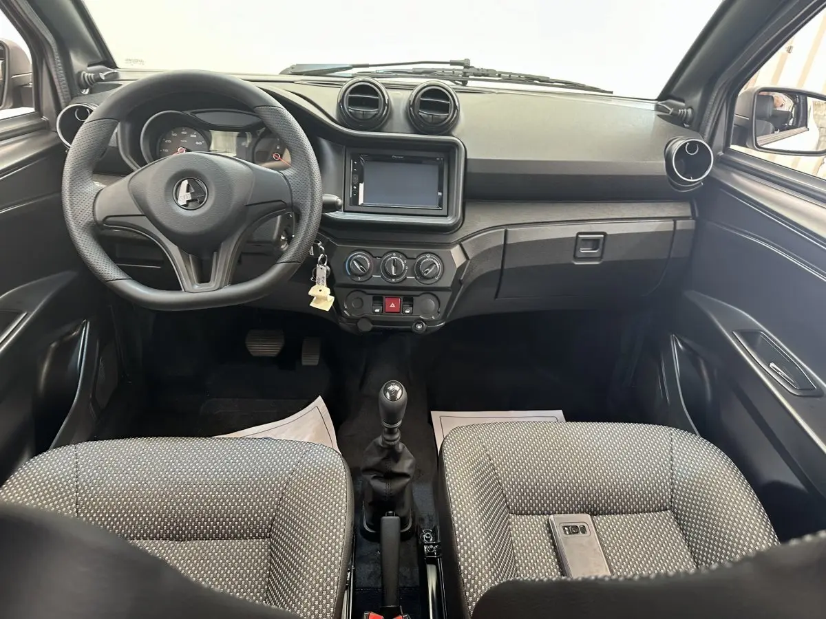 Vue intérieure avant de l'AIXAM AMBITION 0.5 CITY PACK 2026, tableau de bord noir et sièges gris à motifs.