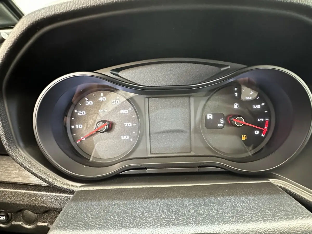 Gros plan sur le tableau de bord noir de l'AIXAM AMBITION 0.5 CITY PACK blanc, affichant la vitesse et le niveau de carburant.