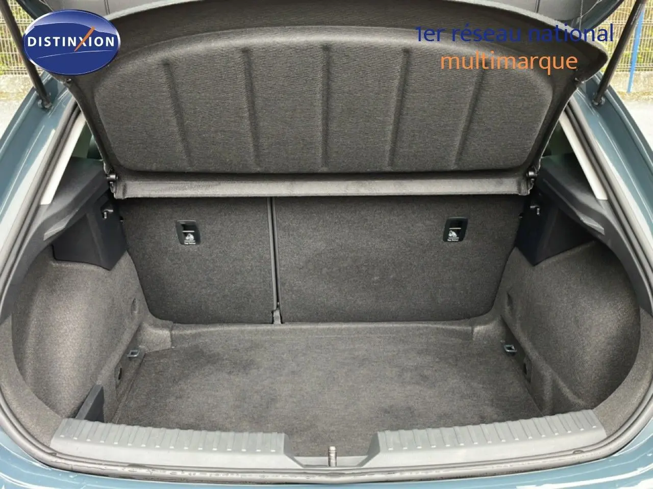 Coffre ouvert vu de l'arrière d'une SEAT LEON gris magnétique métal, montrant un espace de rangement propre et spacieux.
