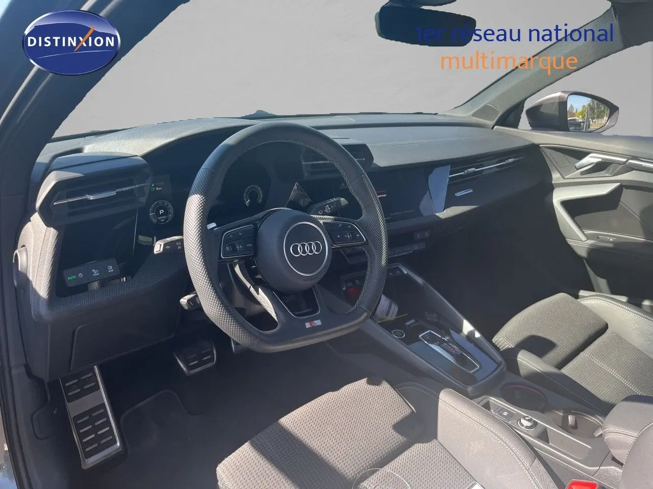 Vue intérieure de l'Audi A3 Sportback 40 TFSIe 2025, tableau de bord et volant multifonction en cuir noir.