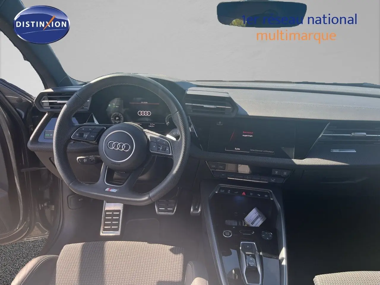 Vue intérieure du poste de conduite de l'Audi A3 Sportback gris Daytona, avec volant multifonction et tableau de bord digital.