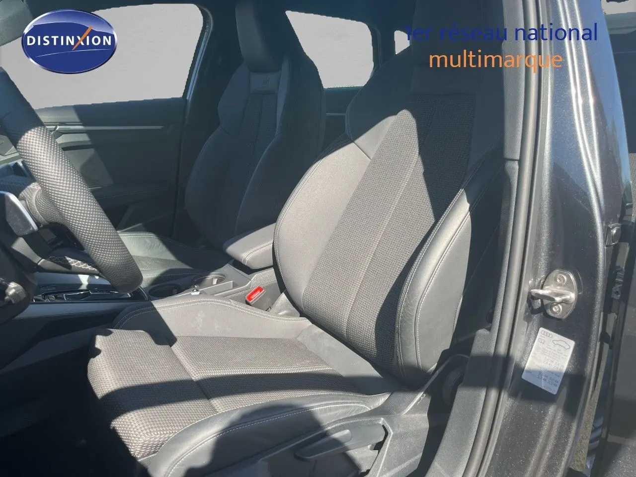 Vue intérieure côté conducteur de l'Audi A3 Sportback 40 TFSIe S-Line 2025 avec sièges en tissu et cuir noir.
