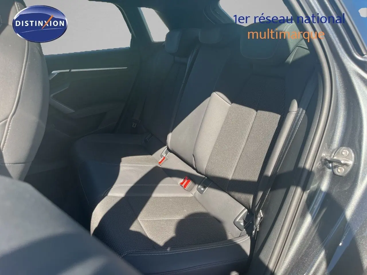 Vue intérieure du siège arrière côté droit de l'Audi A3 Sportback gris Daytona Metal, montrant les ceintures et la texture du tissu.
