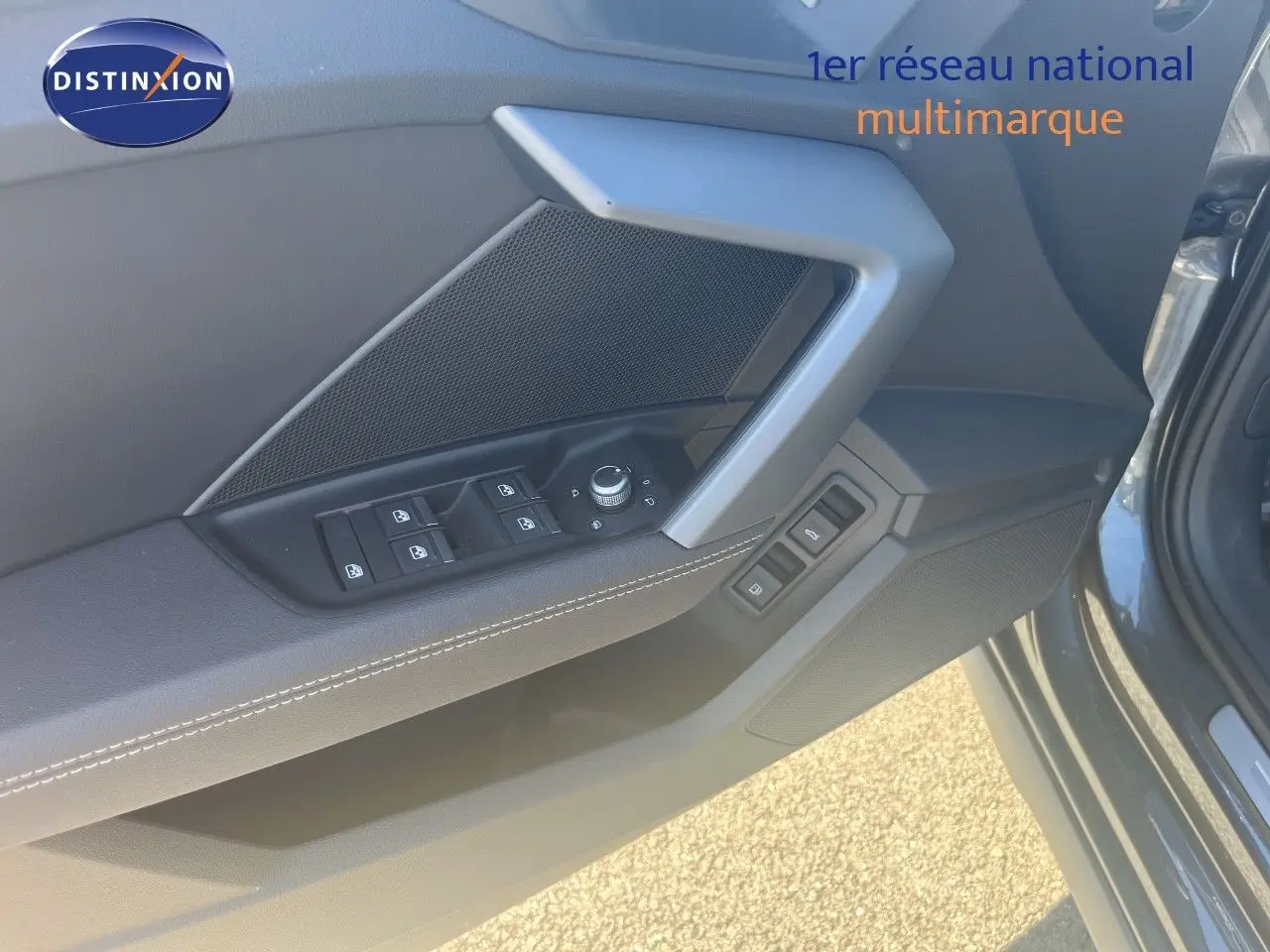 Vue rapprochée de la porte avant gauche de l'Audi A3 Sportback gris Daytona, avec commandes de vitres et rétroviseurs.