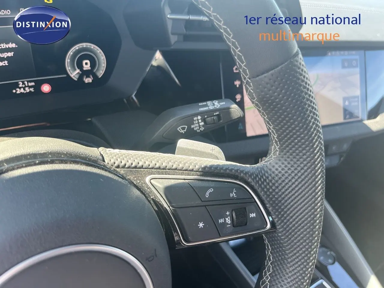 Gros plan sur le volant en cuir perforé avec commandes intégrées et tableau de bord numérique d'une Audi A3 Sportback 2025.