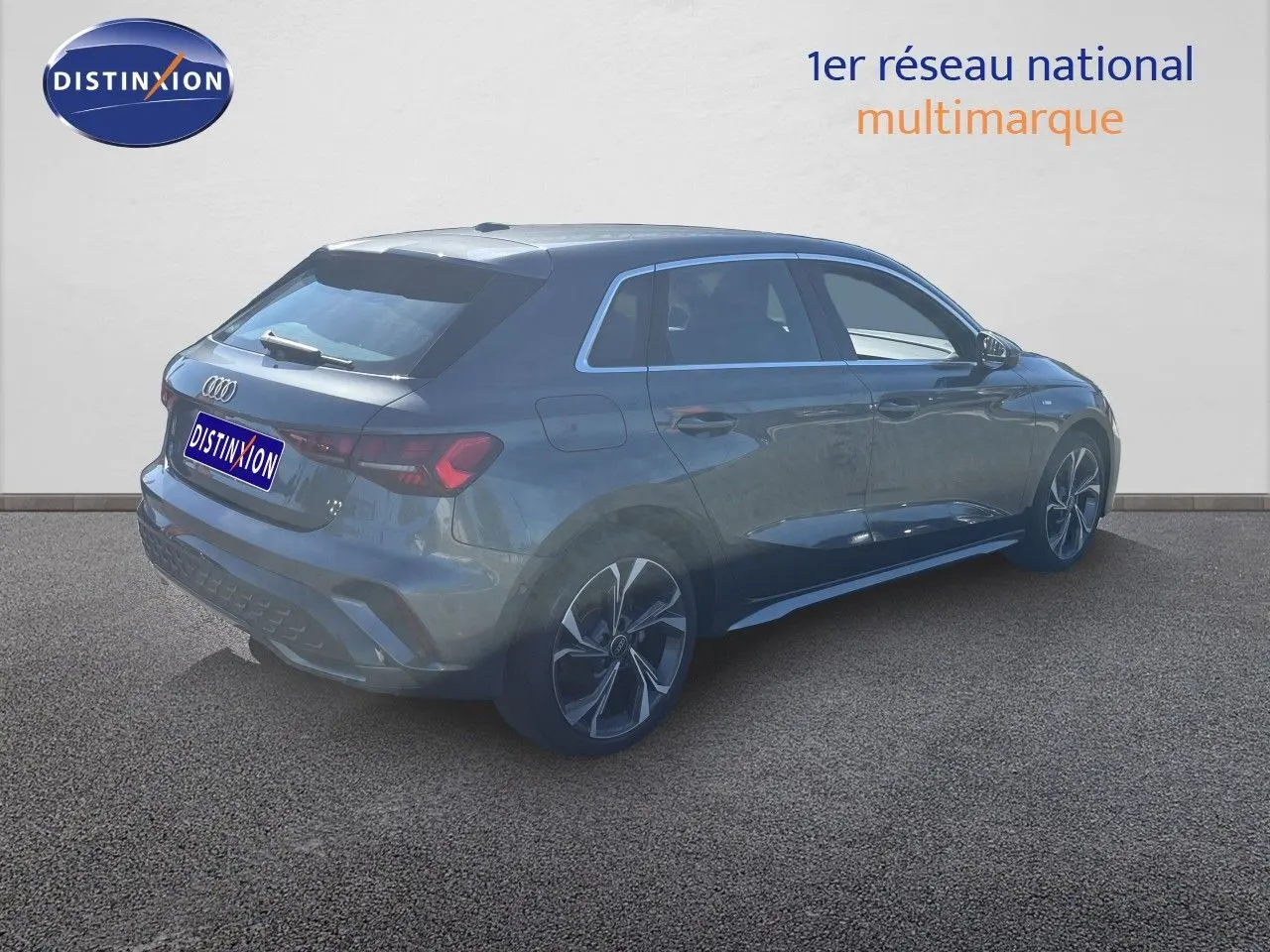 Audi A3 Sportback gris Daytona métal vue 3/4 arrière droit, avec jantes alliage et toit vitré.