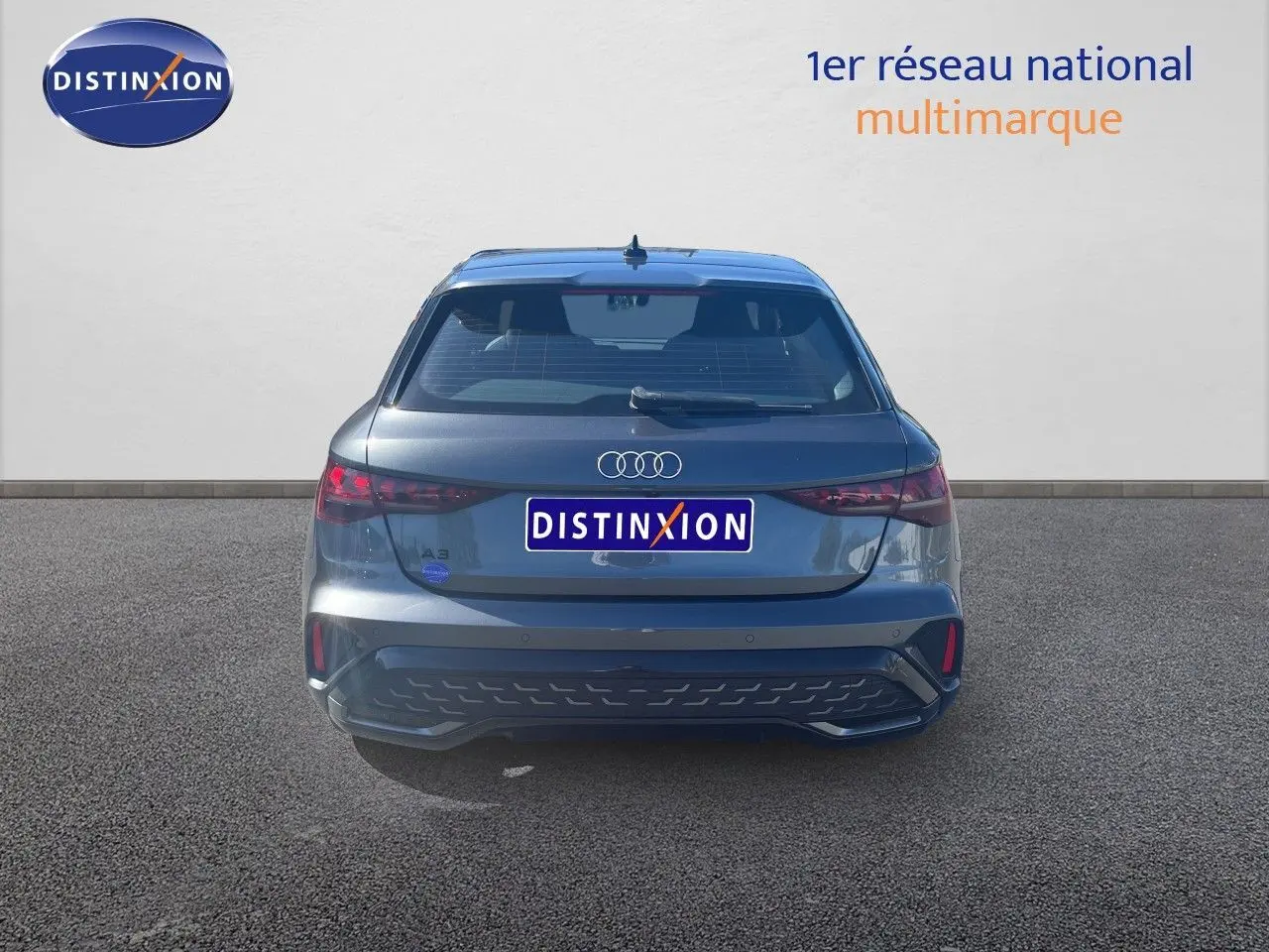 Vue arrière d'une Audi A3 Sportback gris Daytona Metal 2025 avec feux LED et hayon fermé sur sol goudronné.