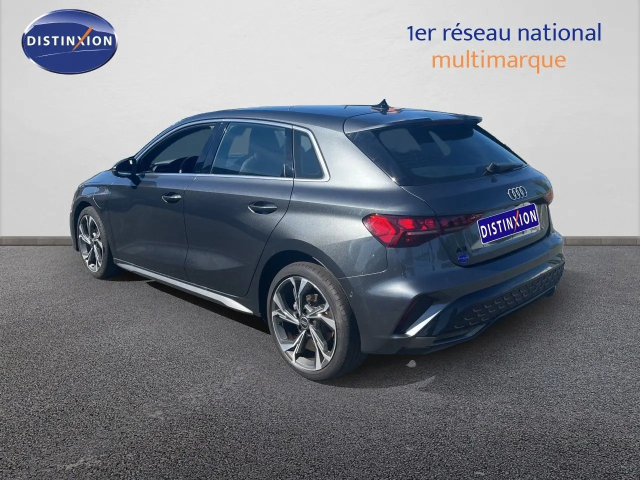 Audi A3 Sportback gris Daytona métal vue 3/4 arrière droit, avec jantes alliage et finition S-Line visible.