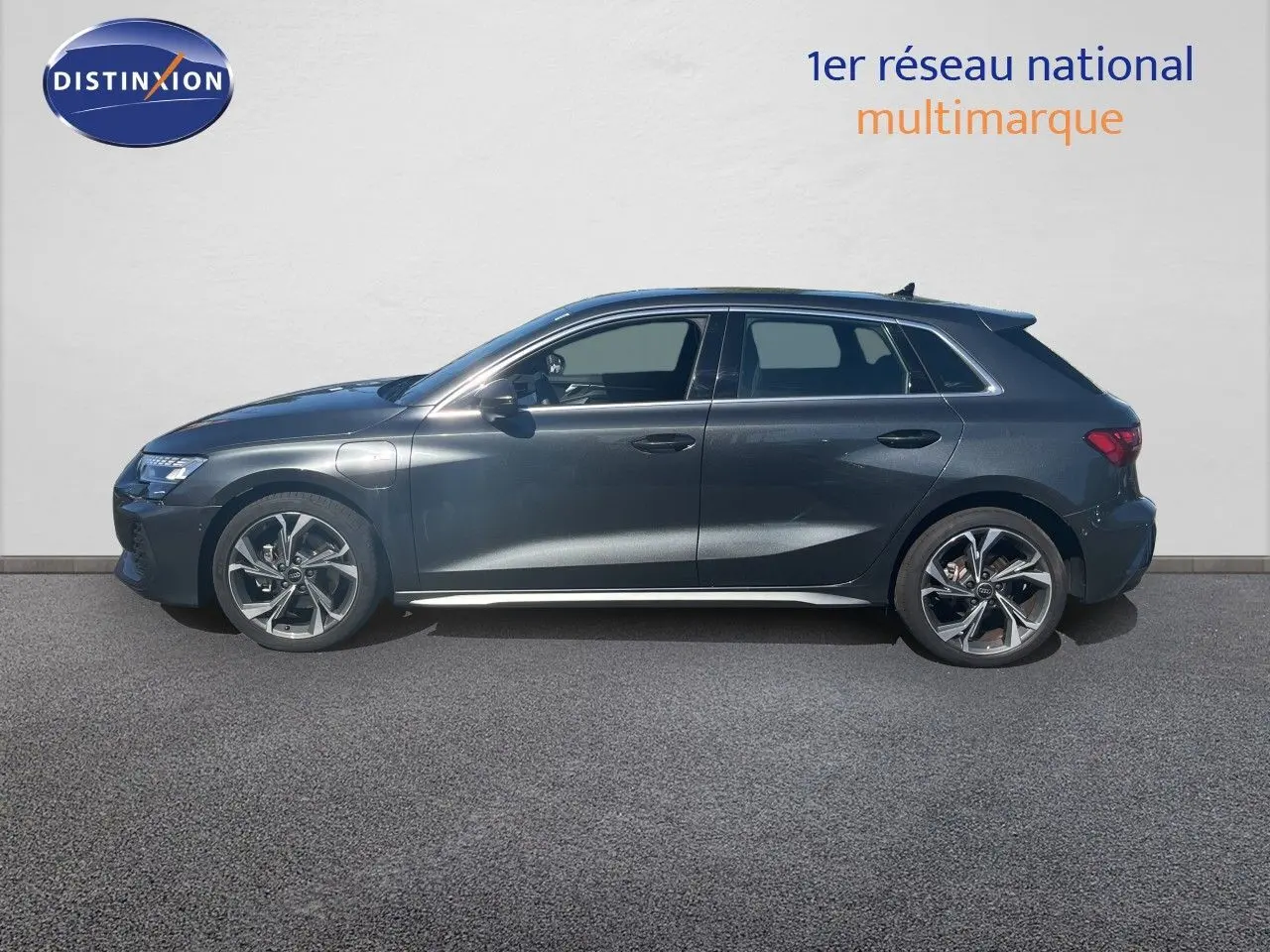 Profil latéral droit d'une Audi A3 Sportback 40 TFSIe gris Daytona métal avec jantes alliage et calandre S-Line visible.