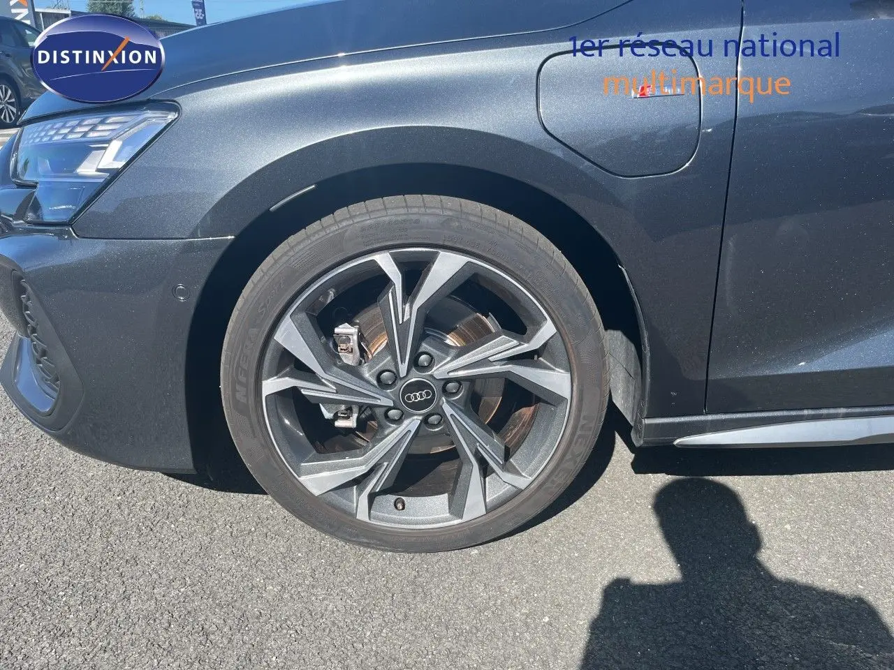 Gros plan sur la roue avant gauche et la partie avant gris Daytona métallisé de l'Audi A3 Sportback 40 TFSIe S-Line 2025.
