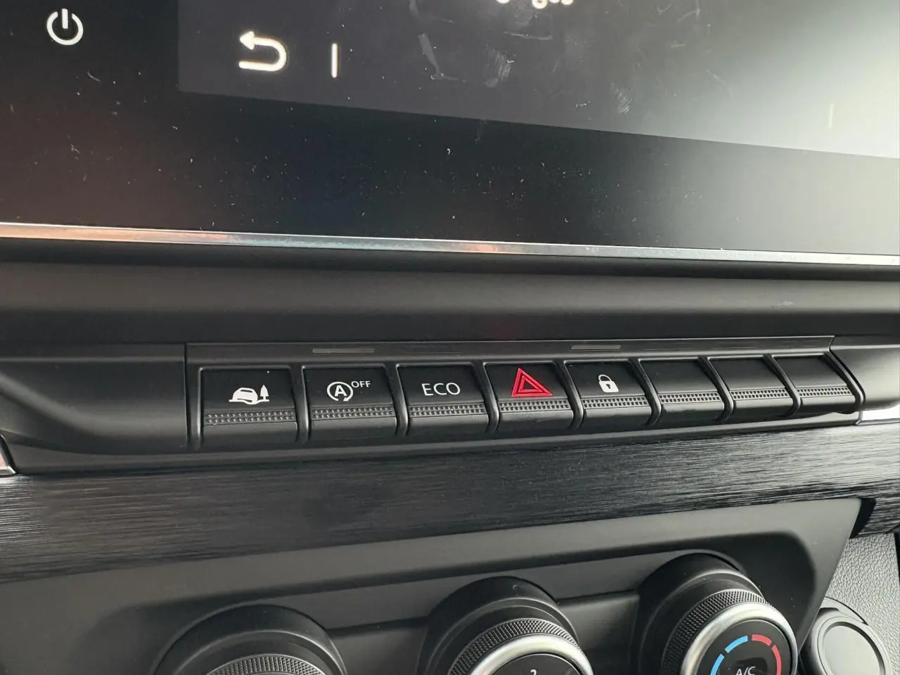 Gros plan sur la rangée de boutons de commande et les réglages de climatisation dans l'habitacle du Renault Trafic Fourgon 2025.
