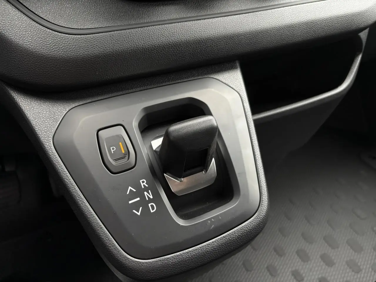 Le levier de vitesses automatique noir du Renault Trafic Fourgon 2025 vu de près avec plancher antidérapant gris.