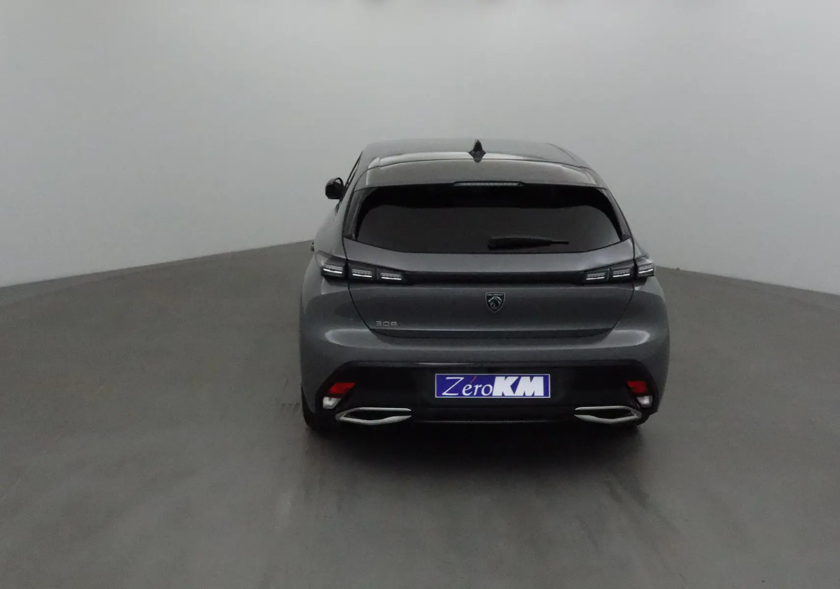 Vue arrière d'une Peugeot 308 gris Sellenium 2025 avec feux LED et double sortie d'échappement chromée.