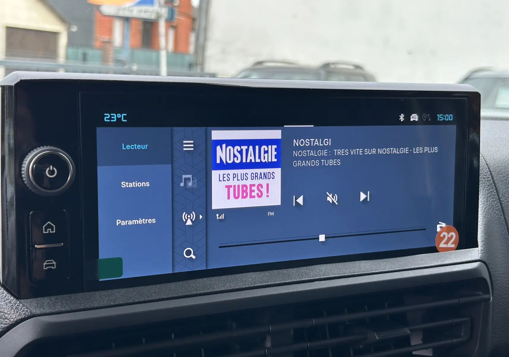 Écran tactile central du tableau de bord du Citroën Jumpy gris titane, affichant la radio Nostalgie à 15h00.