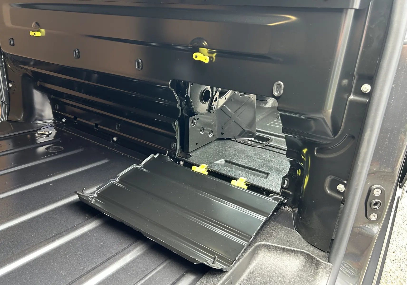 Détail du compartiment de rangement latéral ouvert dans la zone de chargement du Citroën Jumpy gris titane.