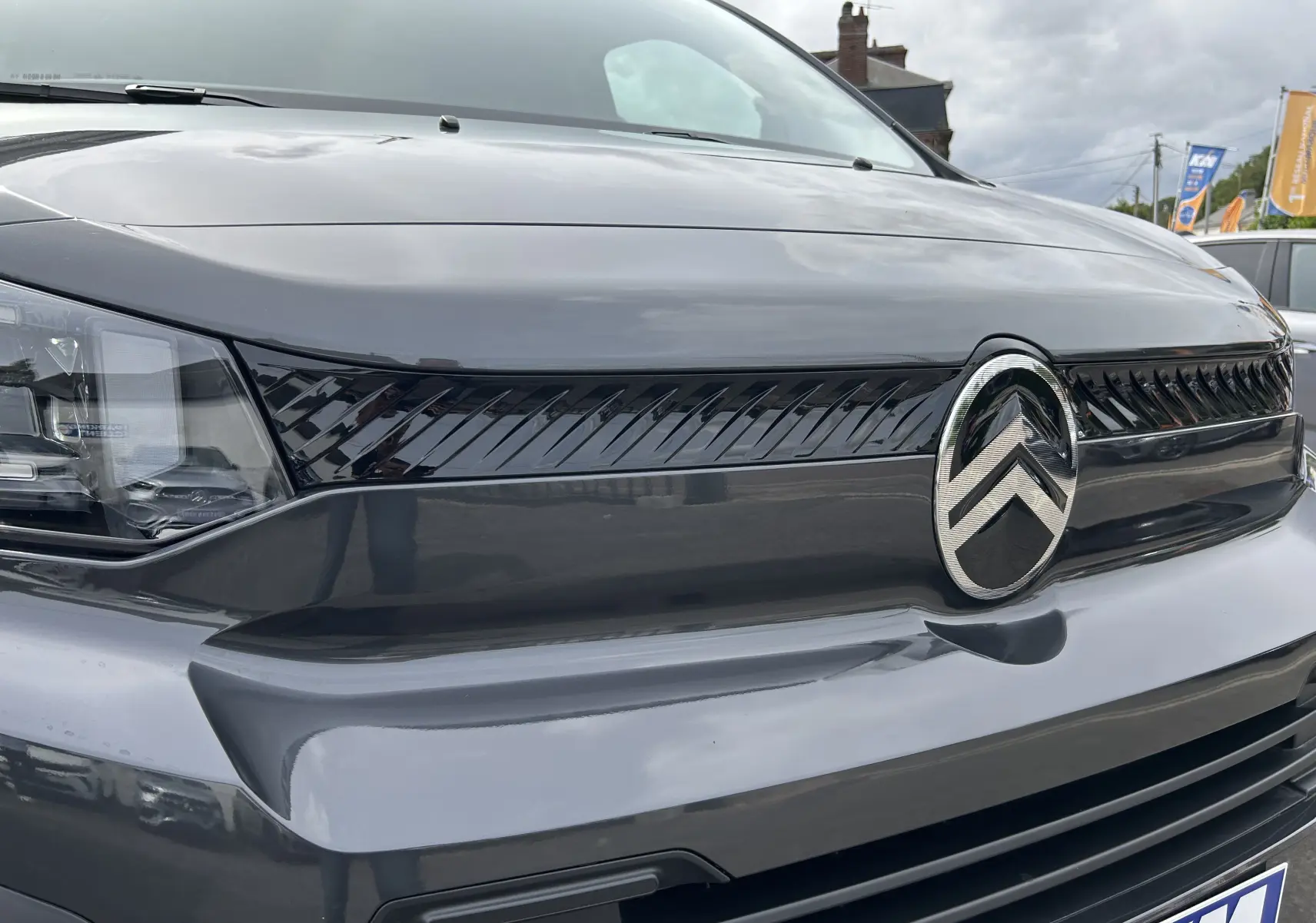 Gros plan sur la calandre avant gris titane du Citroën Jumpy Ph.2 avec logo chrome et optique moderne.