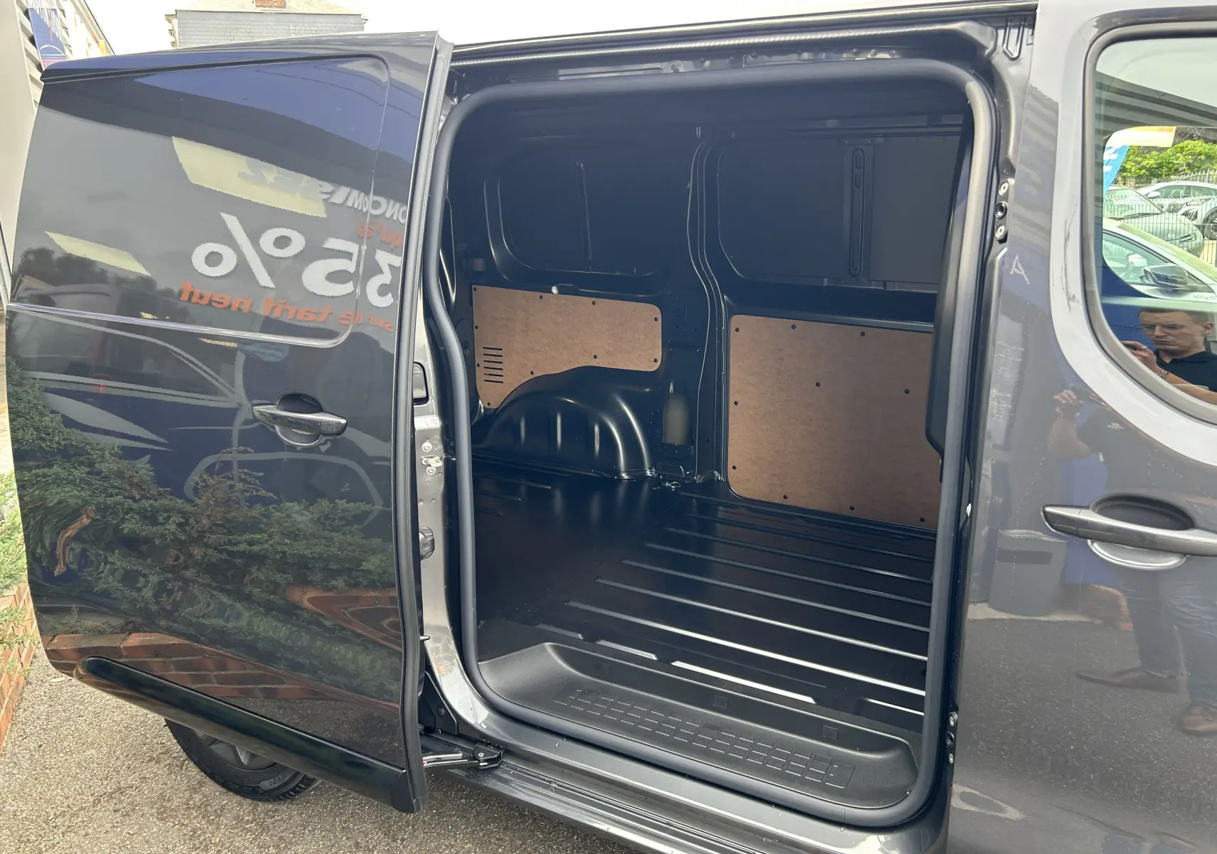 Vue latérale du Citroën Jumpy gris titane 2025 avec porte coulissante ouverte montrant l’espace de chargement vide.