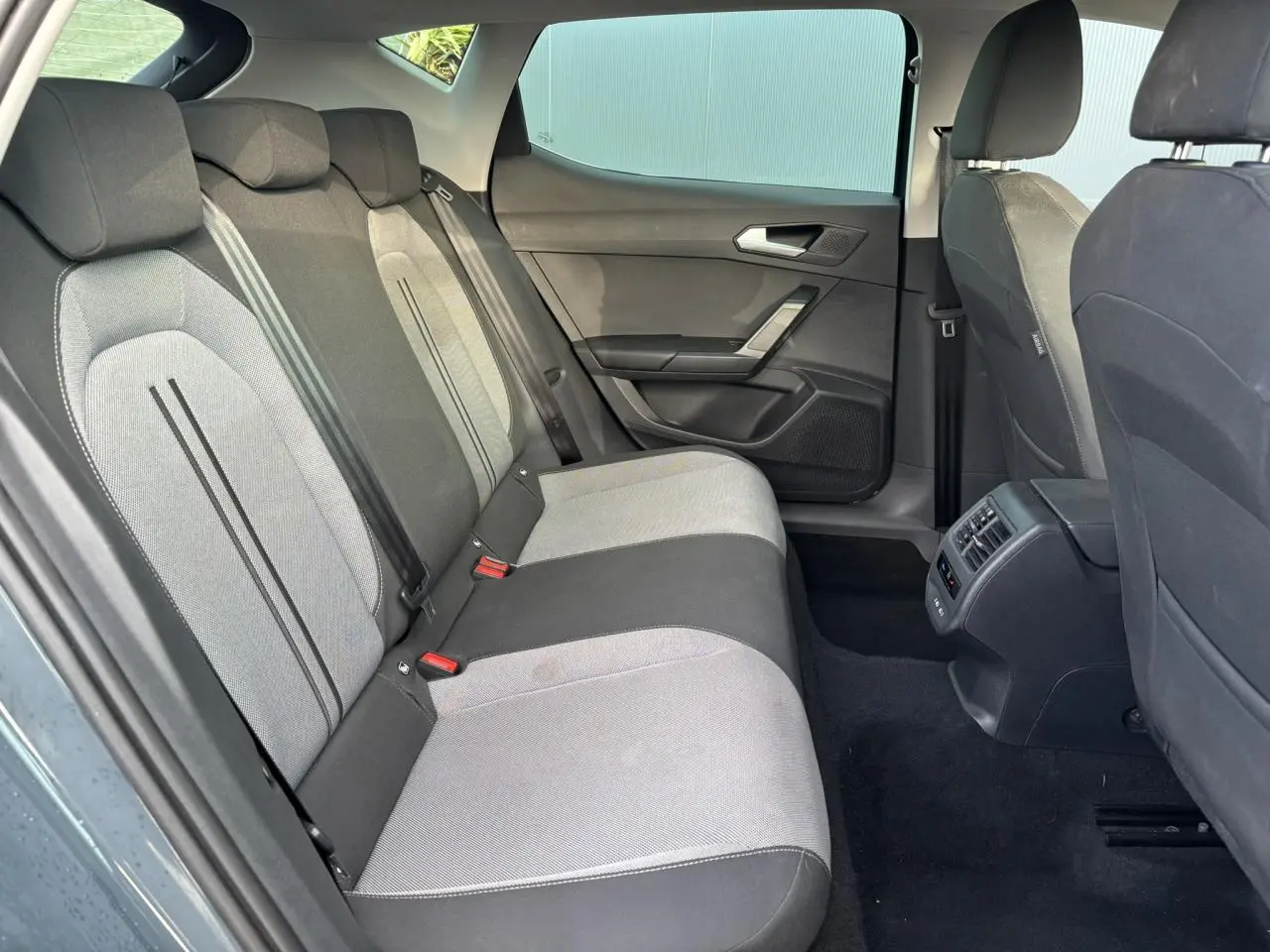 Vue latérale droite de l'habitacle arrière du SEAT LEON 2.0 TDI 115 Style avec sièges bicolores gris et noir.