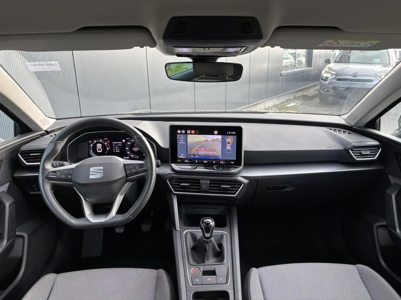 Vue intérieure frontale du poste de conduite du SEAT Leon 2.0 TDI 115 Style 2025 avec écran tactile et boîte manuelle.