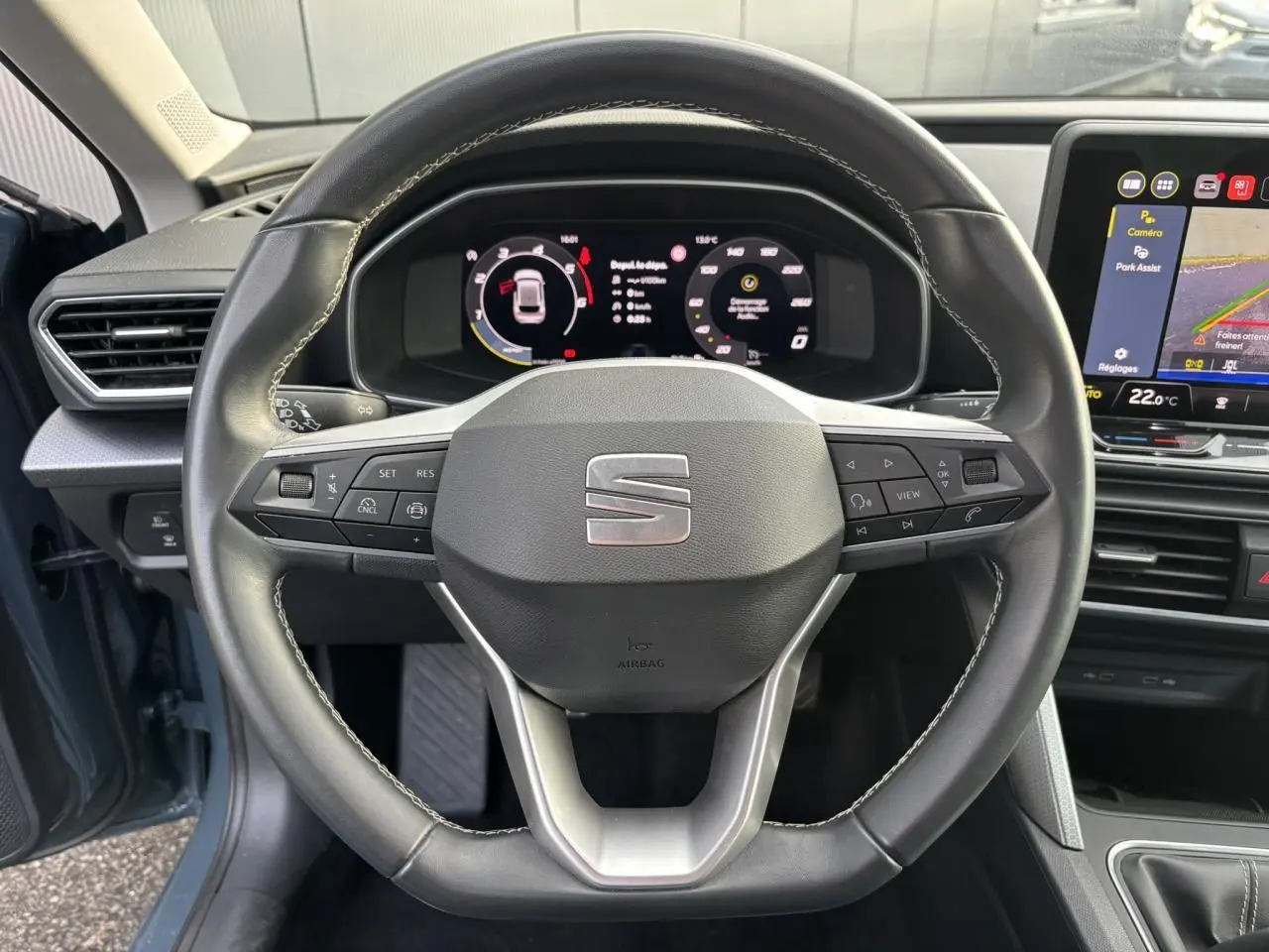 Vue rapprochée du volant cuir multifonction et du tableau de bord numérique du SEAT Leon Bleu Fjord 2025.