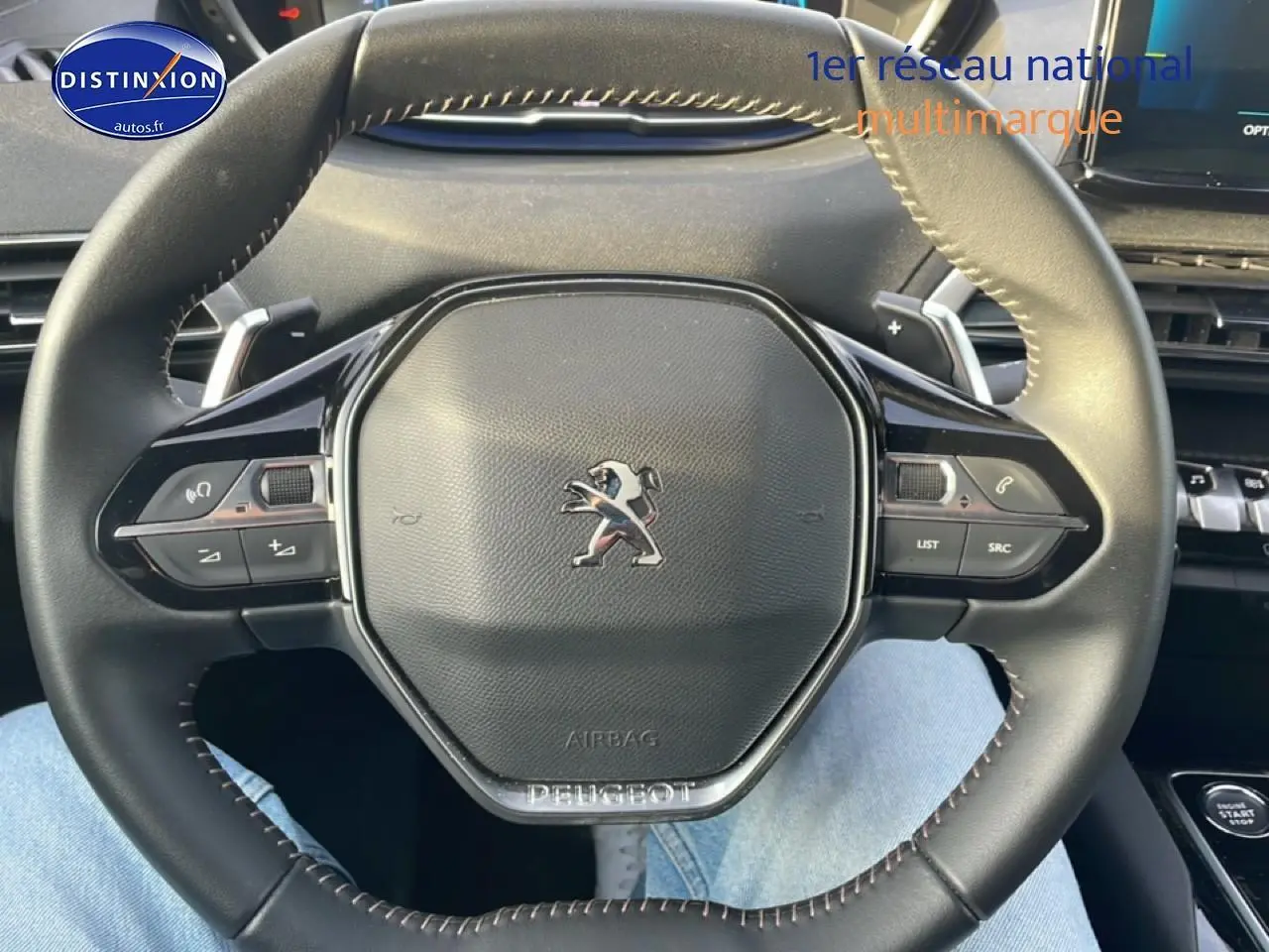 Vue rapprochée du volant cuir multifonction noir du Peugeot 3008 2024, avec commandes intégrées et logo central.