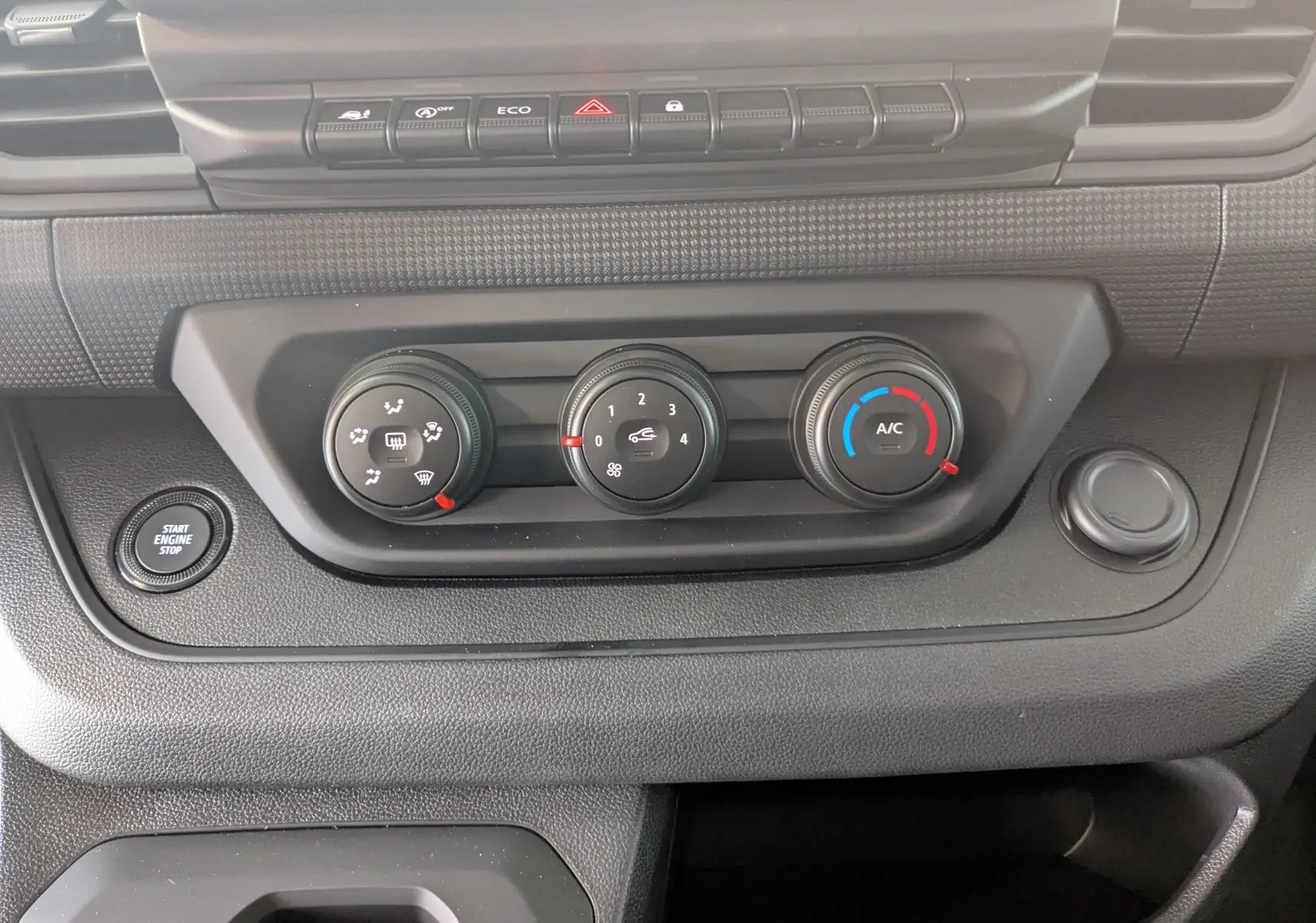 Détail du tableau de bord du Renault Trafic Cabine Approfondie 2025, montrant les commandes de climatisation et le bouton Start Engine Stop.