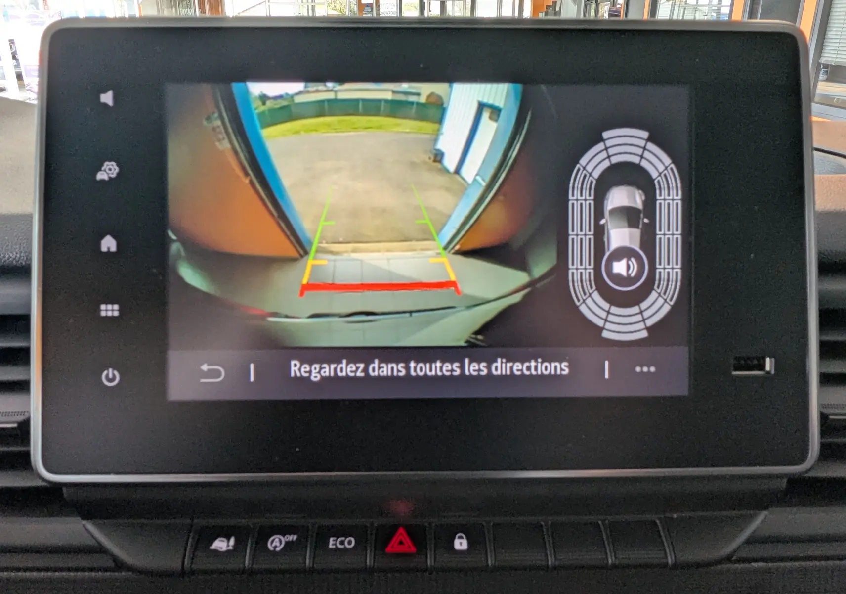 Écran de caméra de recul du Renault Trafic gris comète, affichant les lignes de guidage et capteurs de proximité.