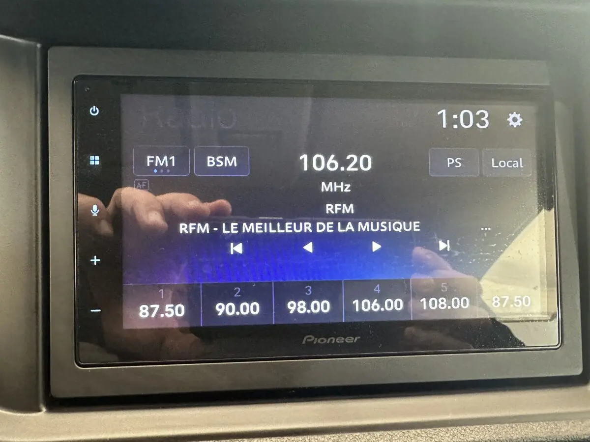 Écran tactile radio Pioneer affichant la fréquence 106.20 MHz avec interface en mode FM1, dans un véhicule.