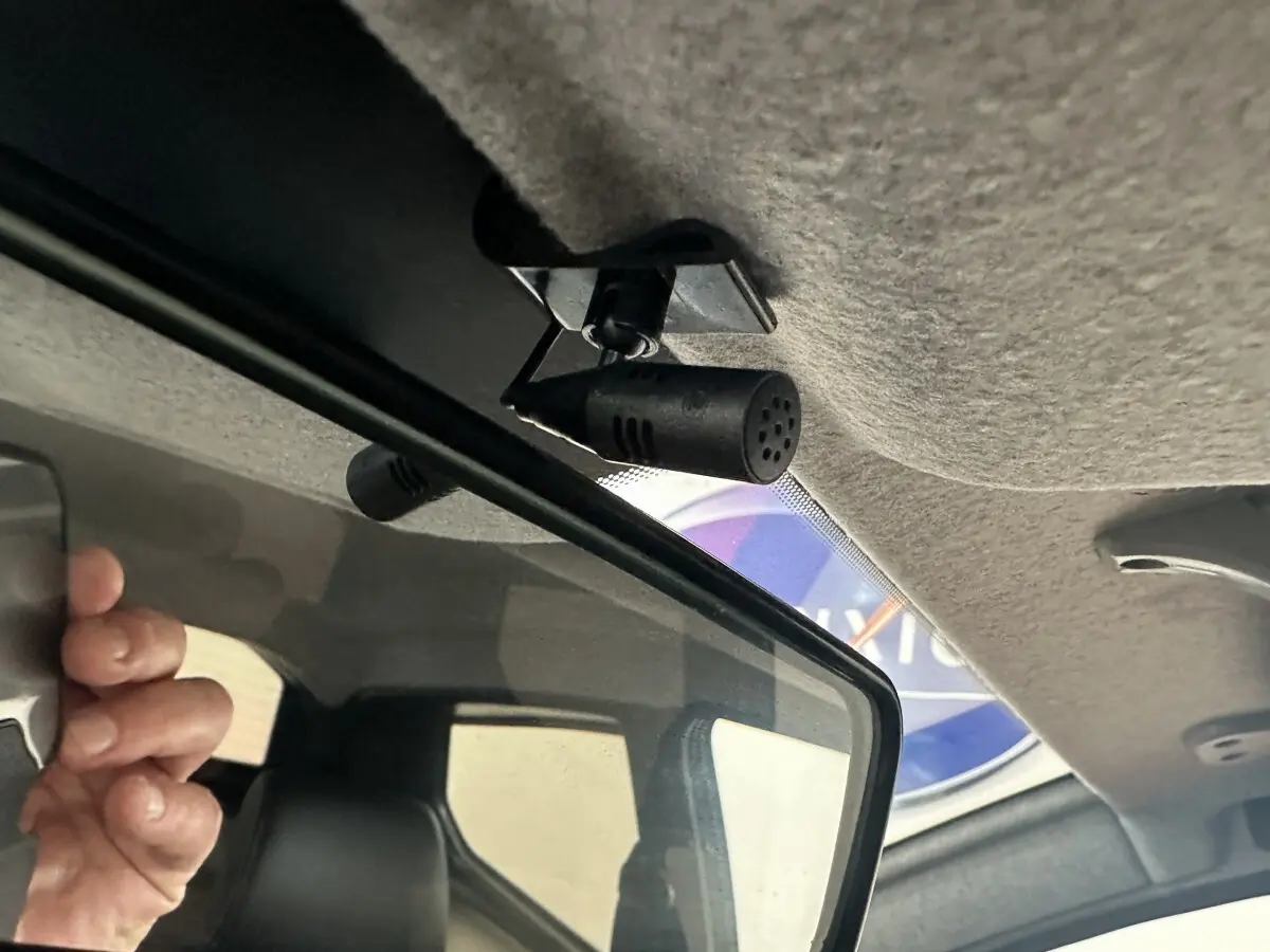 Gros plan intérieur sur le rétroviseur avec micro intégré de l'AIXAM AMBITION 0.5 CROSSOVER blanc, côté conducteur.