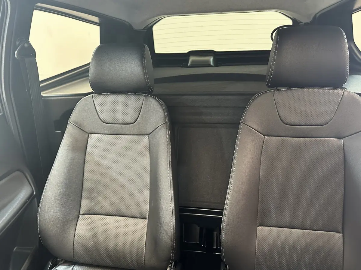 Vue intérieure frontale des sièges avant en cuir noir de l'AIXAM AMBITION 0.5 CROSSOVER PREMIUM 2026.