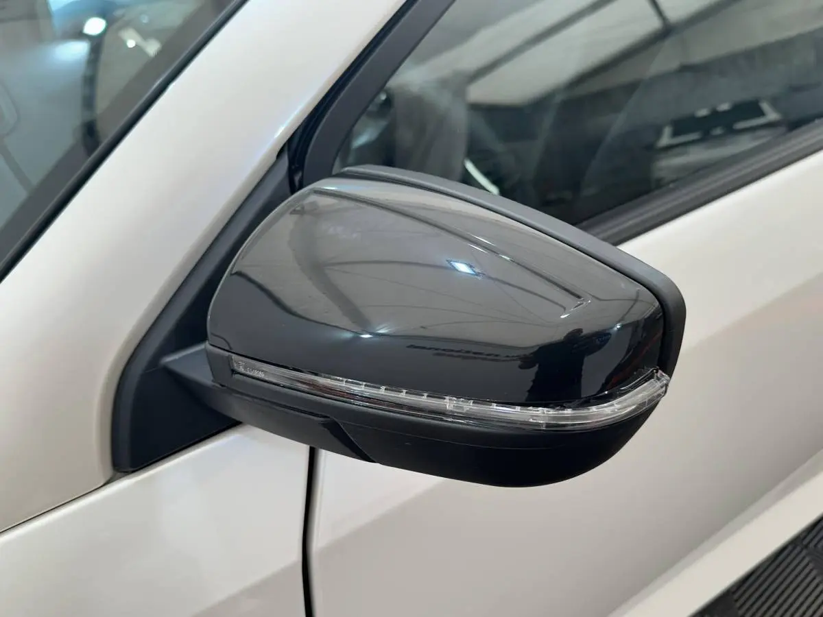 Gros plan sur le rétroviseur caméra côté conducteur noir brillant d'une Aixam Ambition 0.5 Crossover Premium blanche.